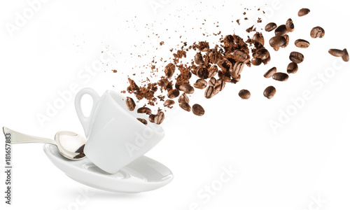 coffee beans and powder spilling out of a cup isolated on white