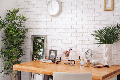 Foto Set of decorative cosmetics and beauty accessories on dressing table indoors