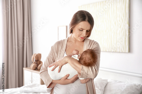 Mother holding sleeping baby at home