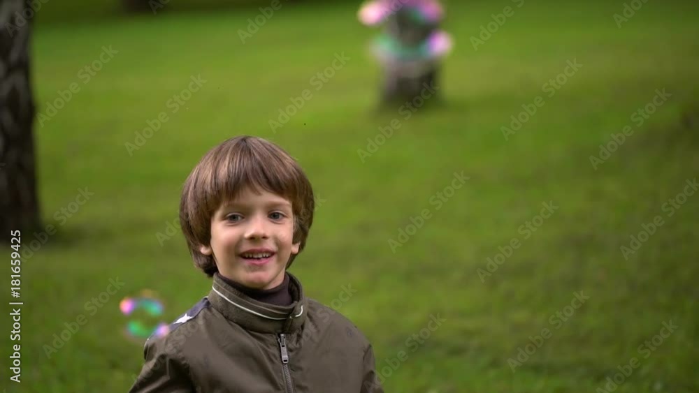 Close up portrait of a very cute young boy who catches soap bubbles. slow-motion Close up portrait of a very cute young boy who catches soap bubbles. slow-motion