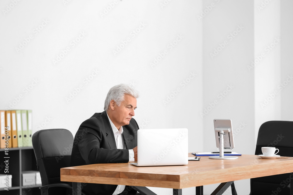 Senior man in formal suit working at desk in office Senior man in formal suit working at desk in office