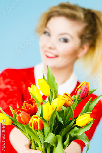 Woman holding yellow and orange bouquet of tulips