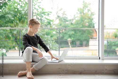 Cute little boy with laptop at home Free Download Cute little boy with laptop at home - GFXLoad