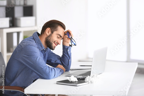 Tired man with laptop in of...
