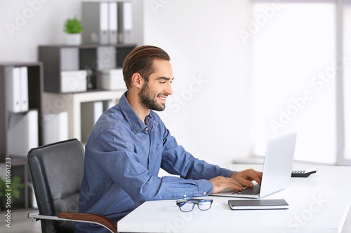 Attractive man with laptop in office