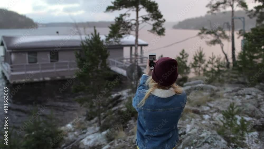 girl is photographing on the phone house on the lake girl is photographing on the phone house on the lake