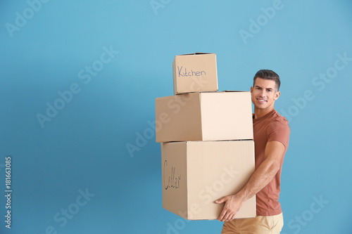 Man with moving boxes near color wall