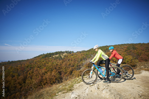 Two female cyclist enjoying the beautiful scenery while out mountain biking. © gzorgz