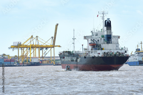 Large cargo ships. It is moving through the water waves and headed to the port one of Thailand.