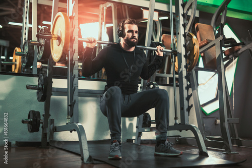 Young handsome man in sportswear exercising at gym