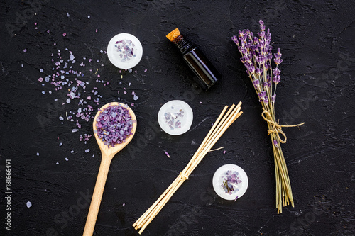 Aromatherapy for relax concept. Lavender branch, spa salt, oil and candles on black background top view