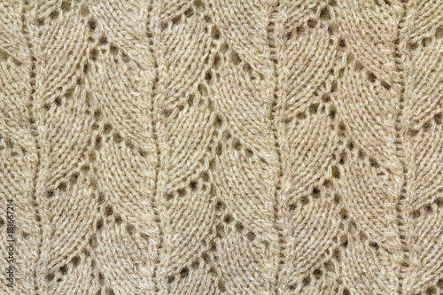 Background texture of beige pattern knitted fabric made of cotton or wool closeup