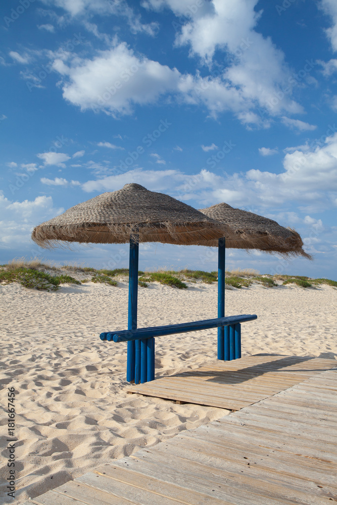 Rows of sun loungers and umbrellas on the beach.Tavira, Portugal