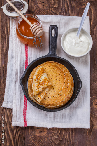 A stack of pancakes with sour cream and honey for Maslenitsa