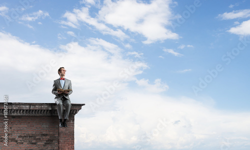 Young businessman or student studying the science on building roof © adam121
