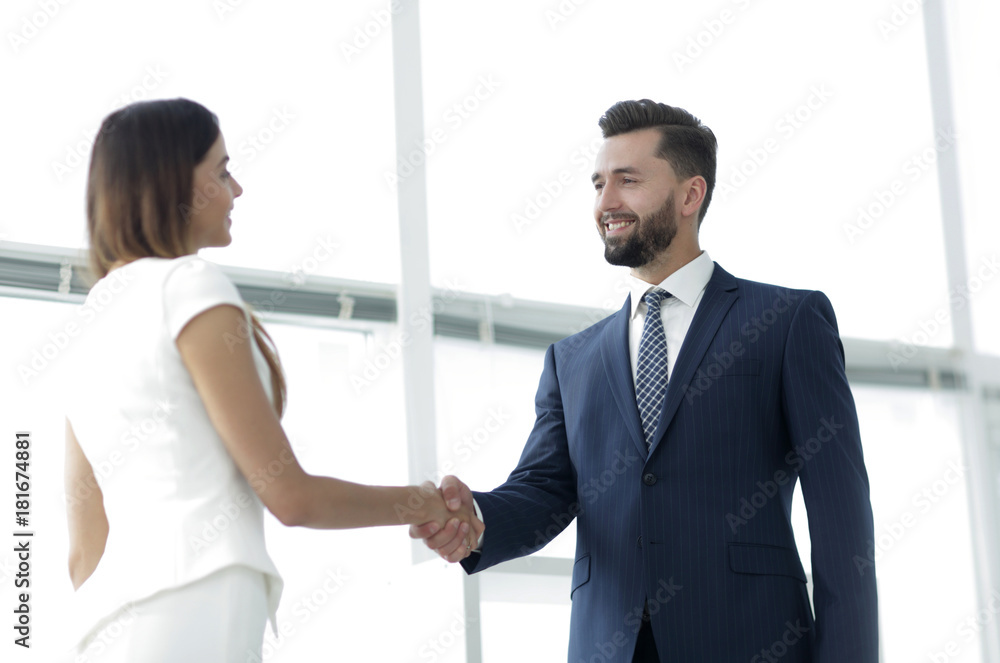 An attractive business man and woman team shaking hands