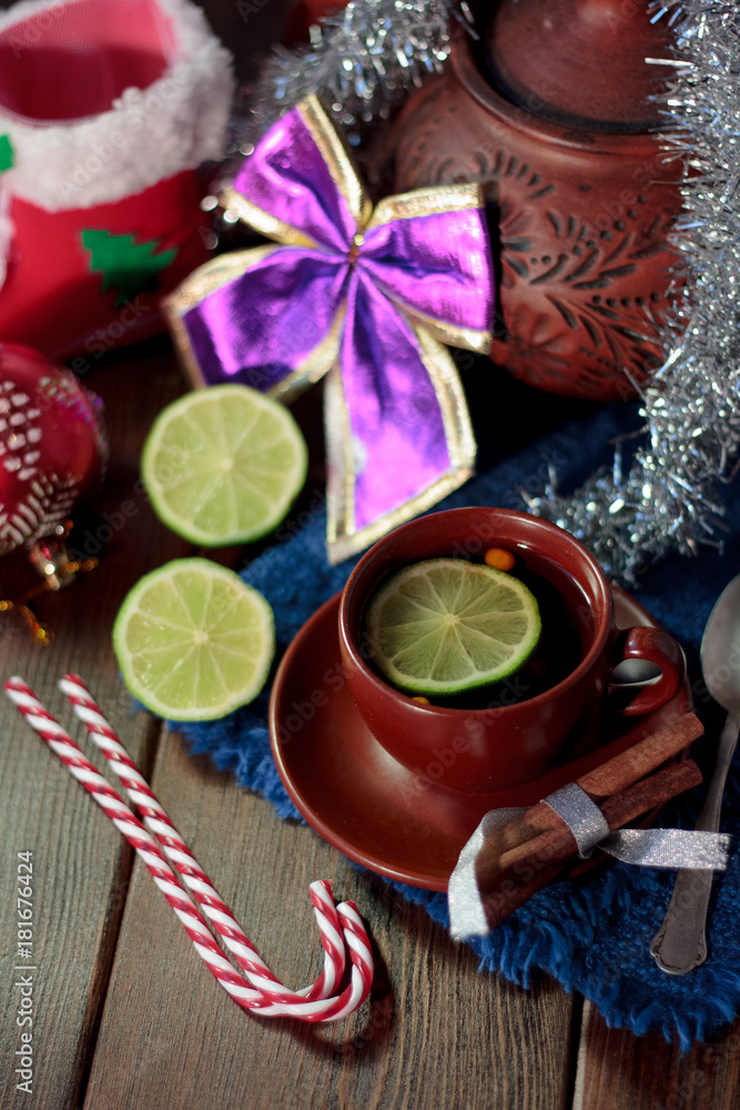 Christmas tea on wooden table with lime and candy canes. Christmas tea on wooden table with lime and candy canes.