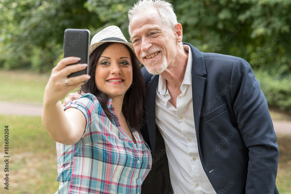 Happy young woman and mature man taking a selfie