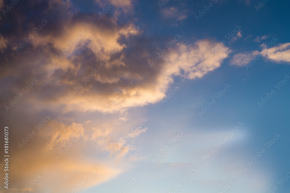 Bright yellow clouds on the blue sky at sunset or sunrise. Space for text