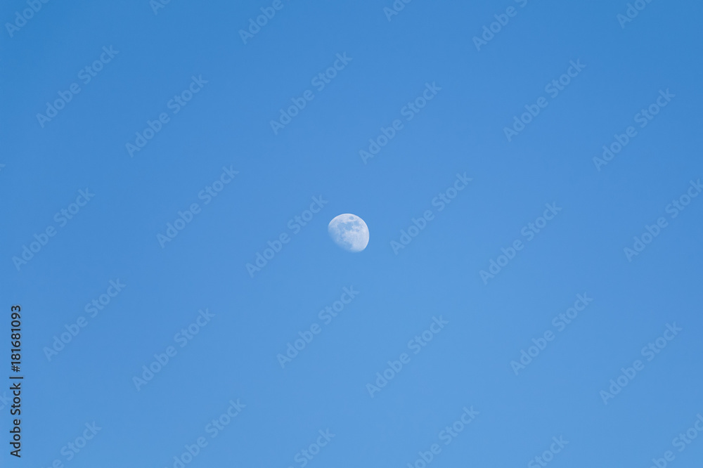 The shape of the moon on a blue sky day The shape of the moon on a blue sky day