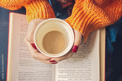 Young woman drinking coffee by the window in warm home