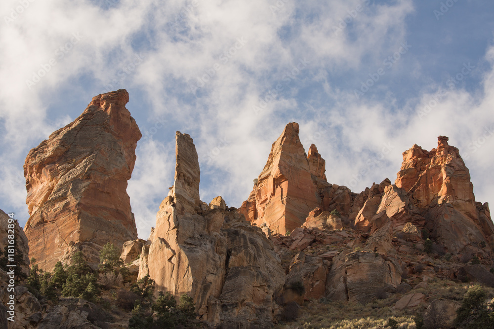 Sandstone towers on Eagle's Crag mountain in Southern Utah with white clouds drifting past