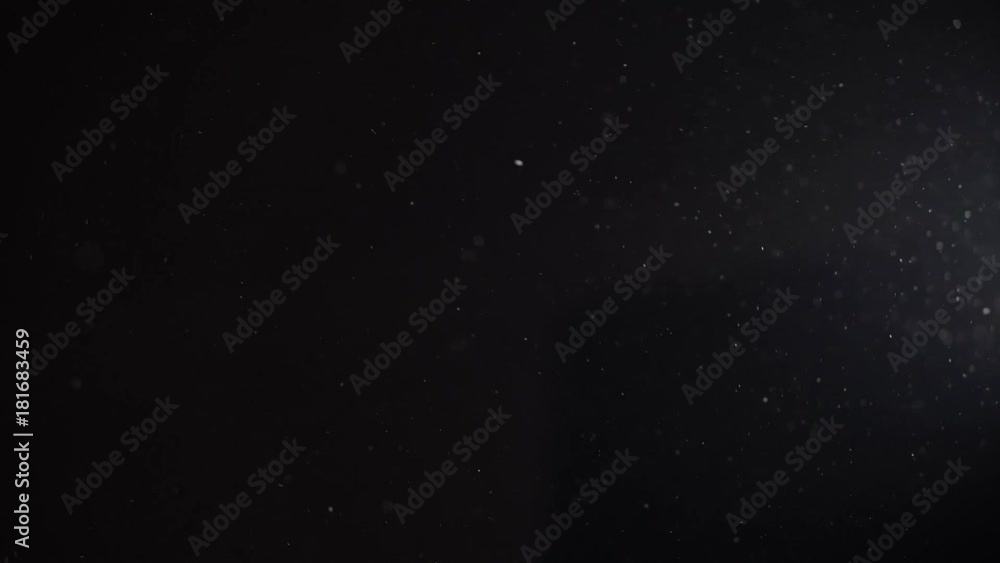 Dust particles in a light beam in a black room background
