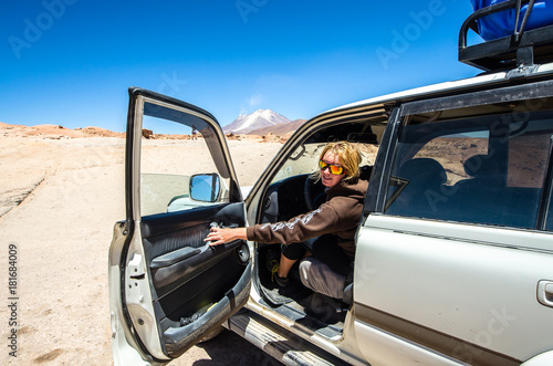 Salar de Uyuni in Bolivia with car. Girl drive a car