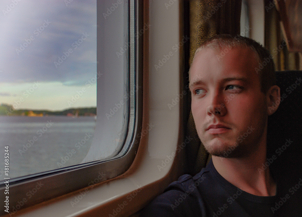 Fototapeta premium European man relaxing and looking out of a window