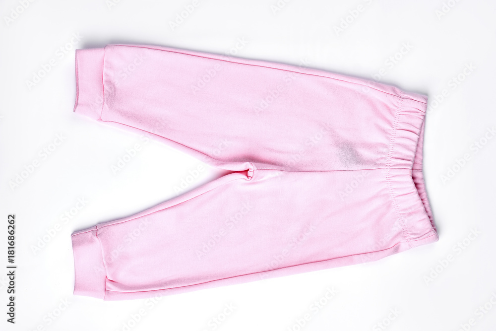 Baby-girl light pink trousers. Top view of new cotton pants for infant girl, isolated on white background.