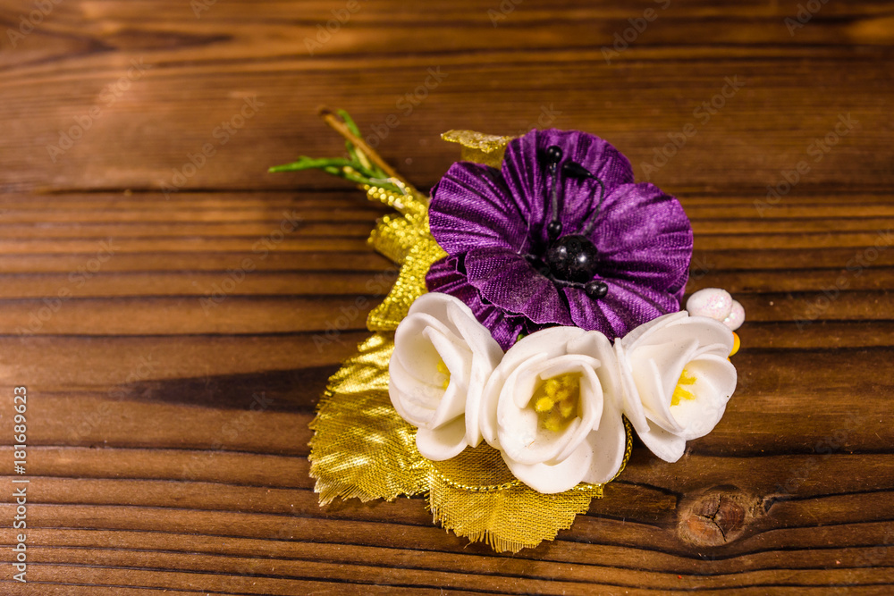 Beautiful multicolored brooch on a wooden table Beautiful multicolored brooch on a wooden table