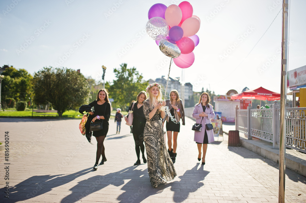 Obraz premium Five girls wear on black walking with balloons at hen party.