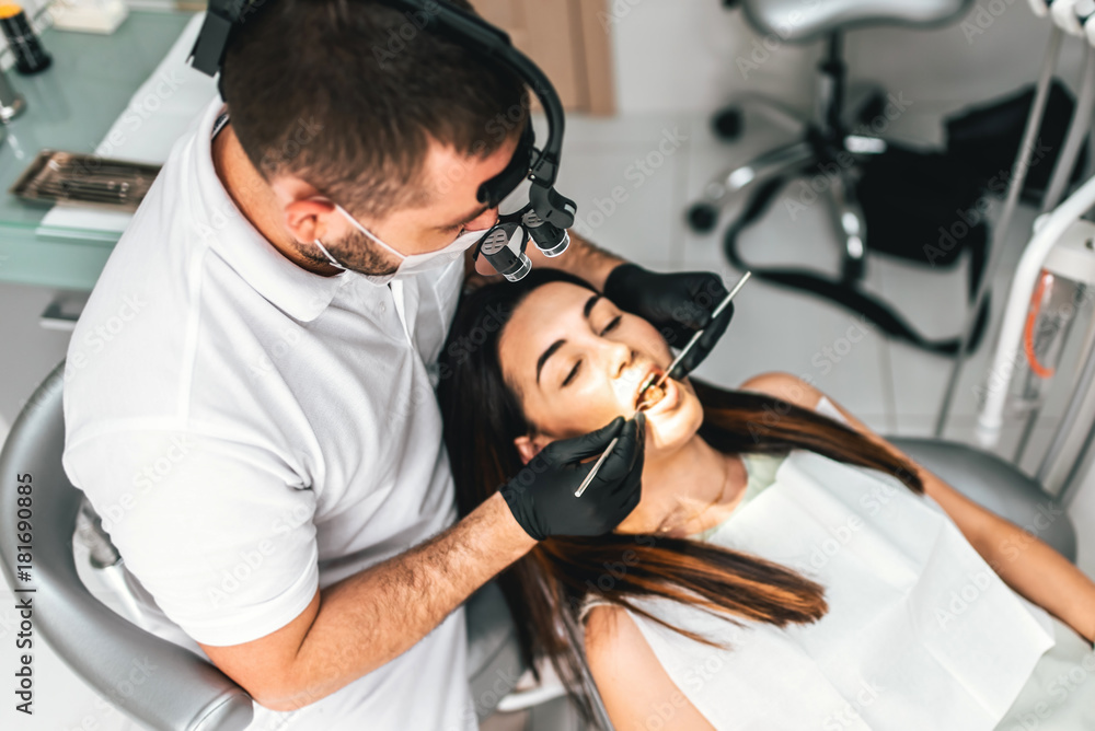 Dentist working in dental clinic with female patient in the chair Dentist working in dental clinic with female patient in the chair