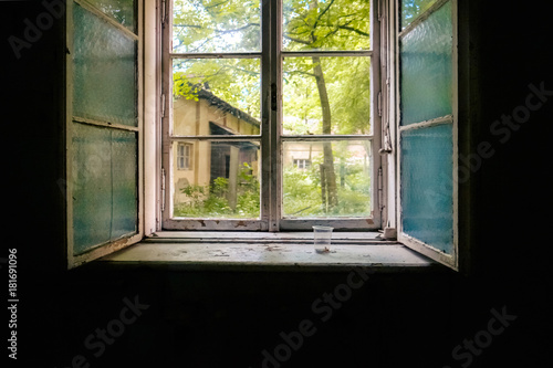 Old double-glazed window in the darkness of the room of an abandoned building