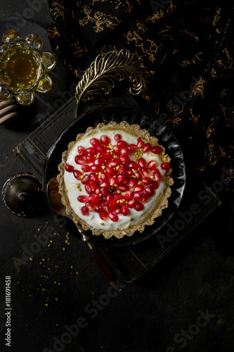 Yogurt Honey Tart covered in fresh pomegranate seeds photo