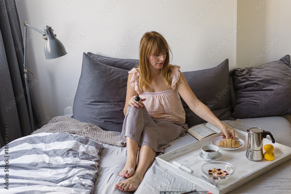 Morning without a job- woman spent the morning in bed with breakfast and a book