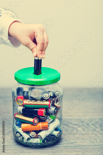 Children hand collecting used batteries
