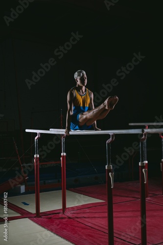 Male gymnast practicing gymnastics on the horizontal bar