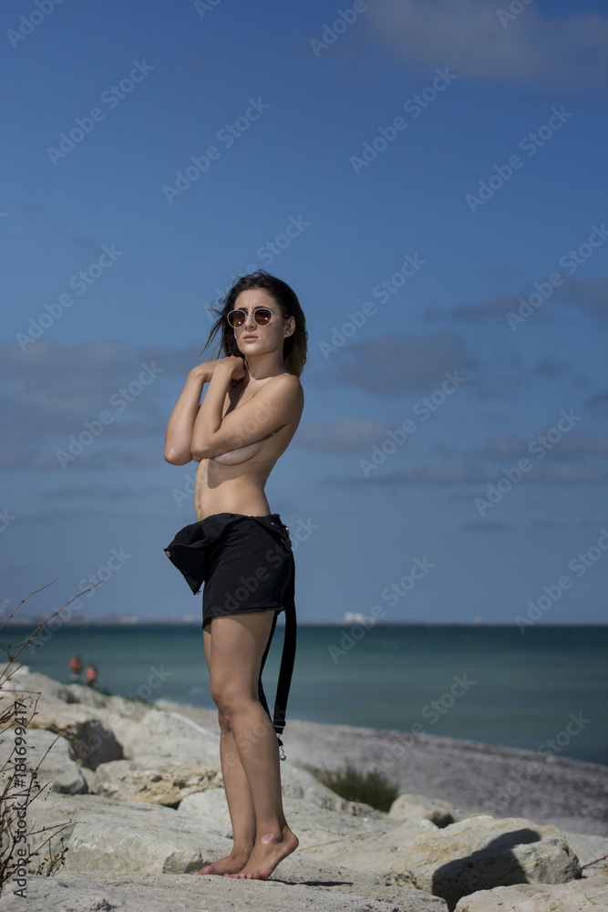 Beautiful young sexy woman enjoying nature by the sea