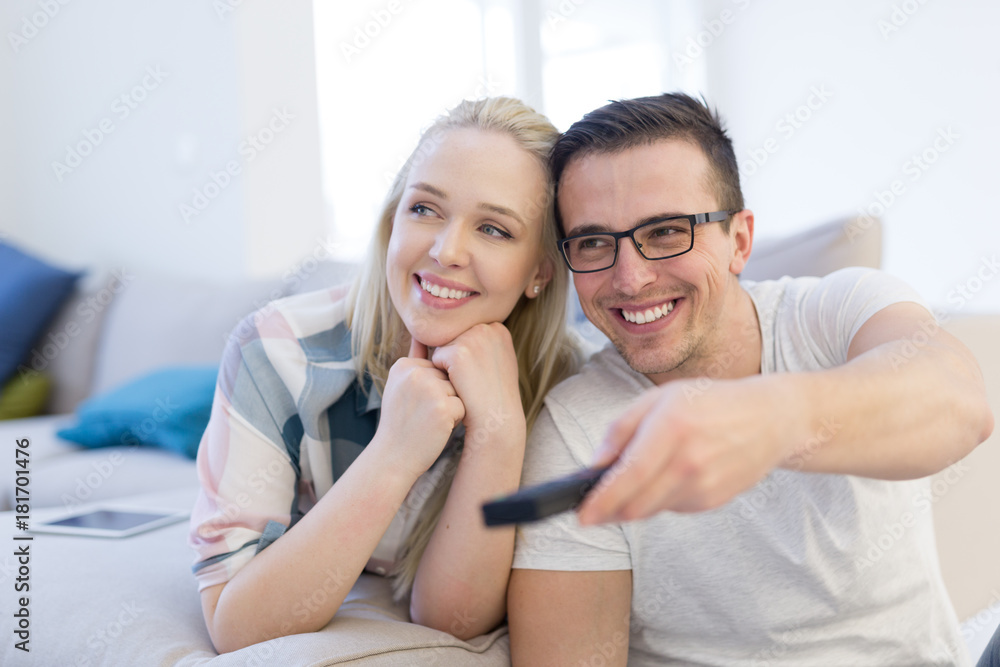 Young couple on the sofa watching television Young couple on the sofa watching television
