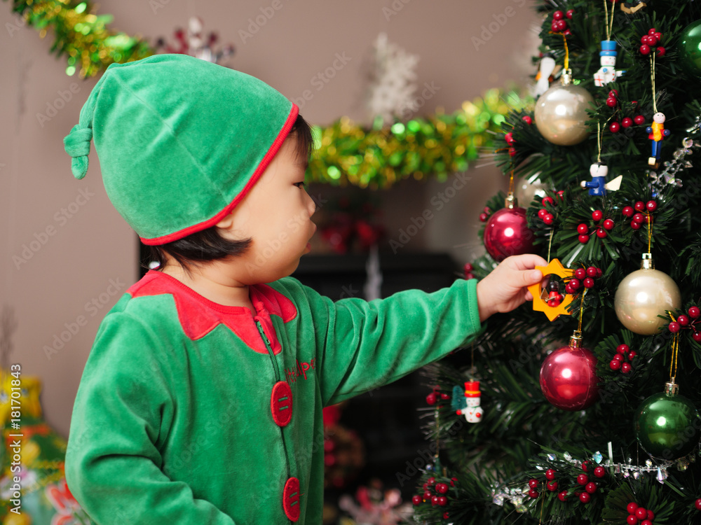 baby girl decorating Christmas tree baby girl decorating Christmas tree