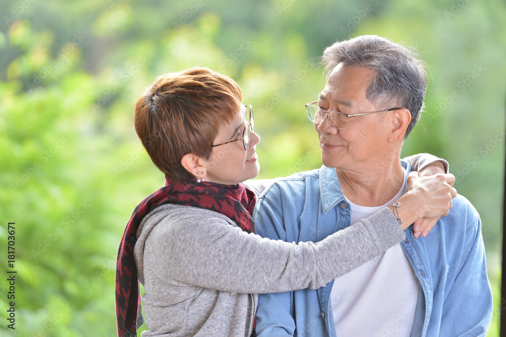Fototapeta premium Portrait of happy romantic senior couple outdoor at the green nature background