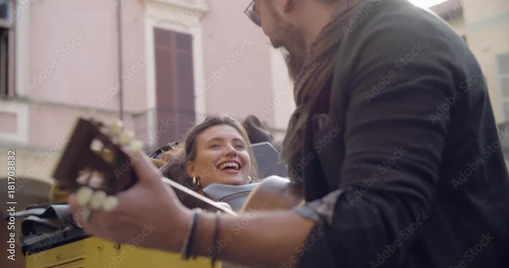 Man smiling while playing guitar music with girlfriend.Woman listening to boyfriend singing song.Caucasian couple in love roadtrip vacation italian travel on convertible vintage car.4k handheld video Man smiling while playing guitar music with girlfriend.Woman listening to boyfriend singing song.Caucasian couple in love roadtrip vacation italian travel on convertible vintage car.4k handheld video