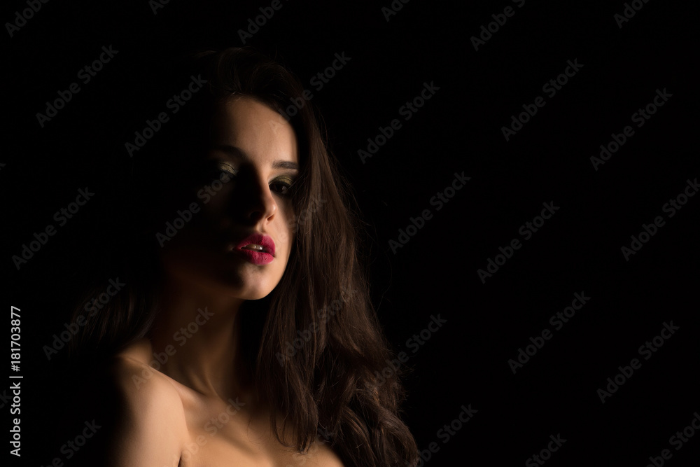 Glamor young woman with bright makeup with naked shoulders posing in the shadow Glamor young woman with bright makeup with naked shoulders posing in the shadow