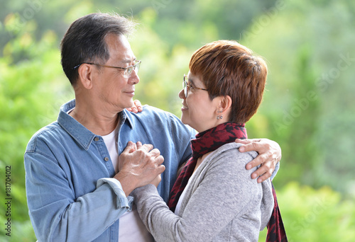 Portrait of happy romantic senior couple outdoor at the green nature background © amenic181