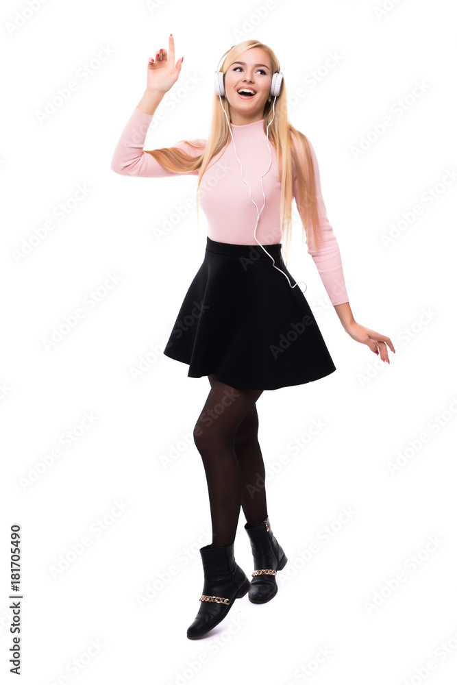 Fototapeta premium Full length of cheerful young woman listening to music from mobile phone over white background