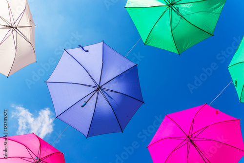 Colourful umbrellas urban street decoration. Hanging colorful umbrellas over blue sky, tourist attraction