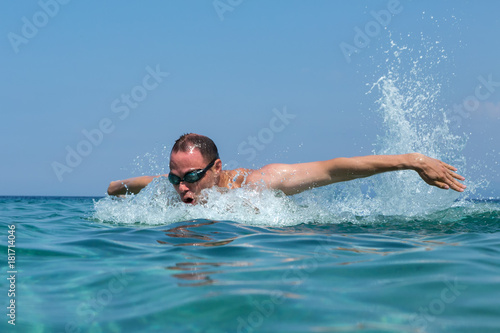 Tourist man in swimming sports glasses is floating in the Aegean Sea on the coast of Sithonia Peninsula © Julia Mashkova