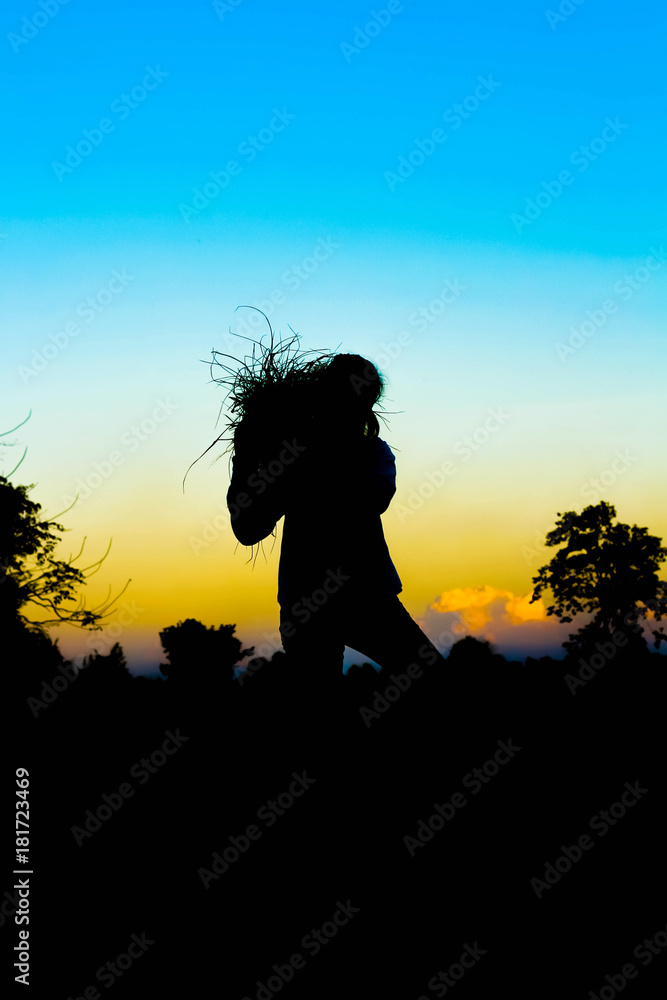 Shadow of women farmer stand on straw in evening time