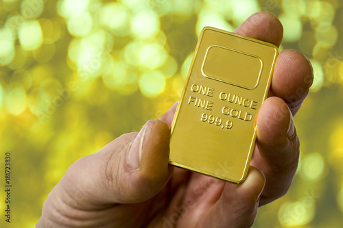 Fotografía A small ingot of gold in the hand. One ounce of gold. Show gold.